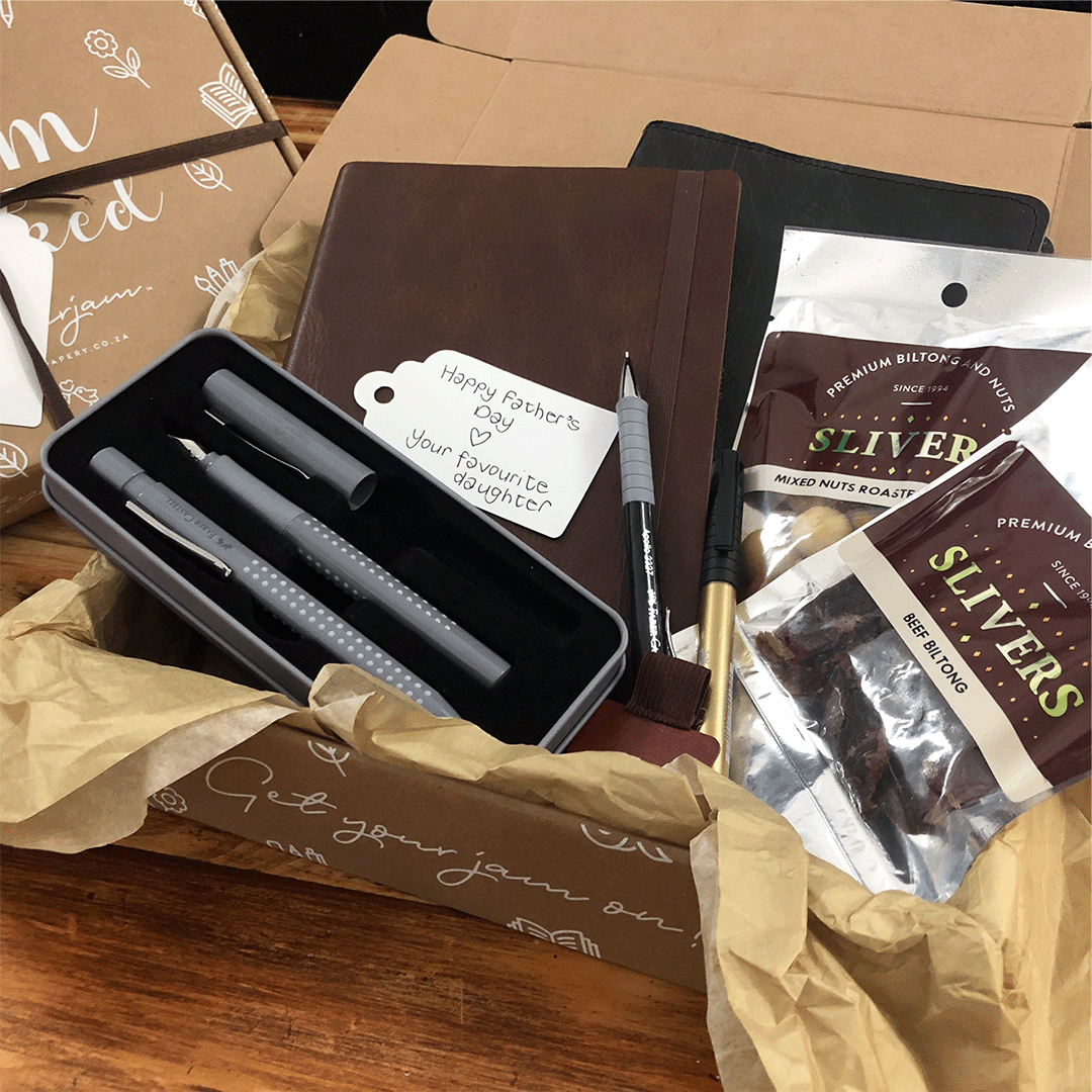 Image shows a stationery box filled with a variety of black and brown products