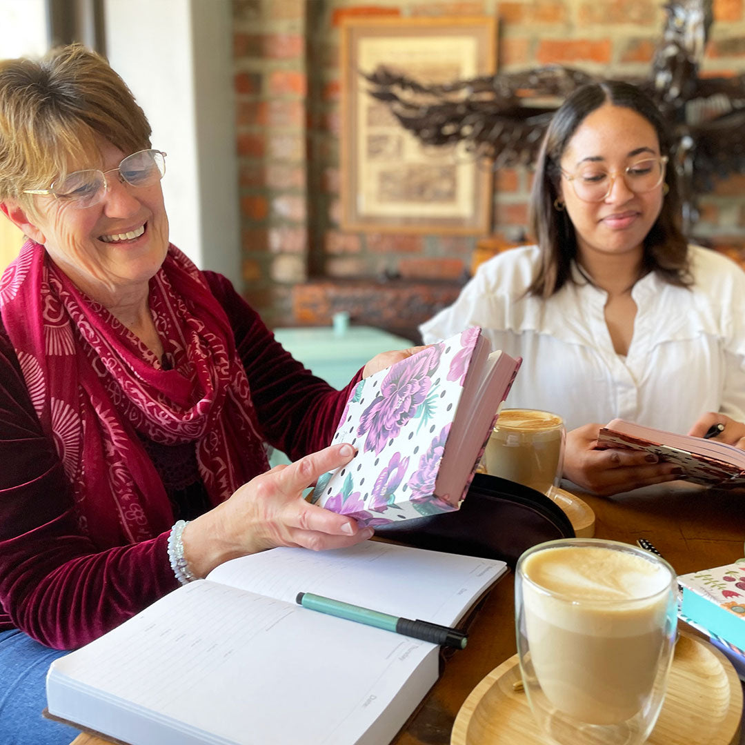 Image shows two women holding MOM/WOW diaries 