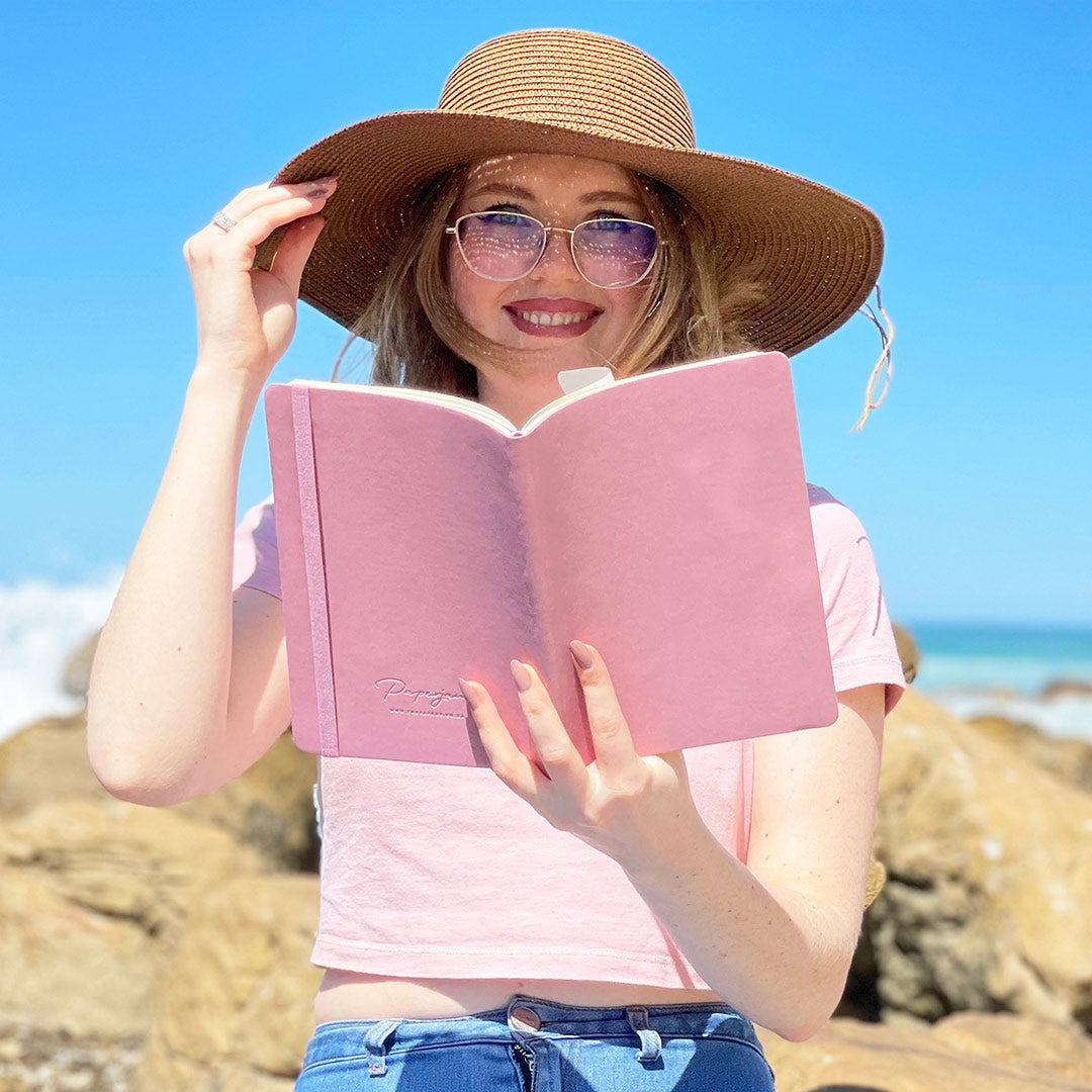 Image shows a woman holding up a Flexi softcover journal in hand