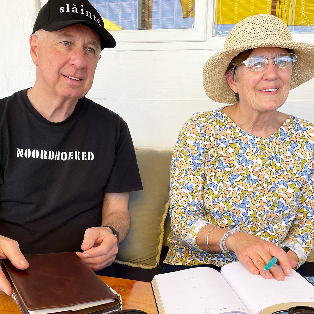 Image shows a man and woman holding a Multiplanner and Rustik journal