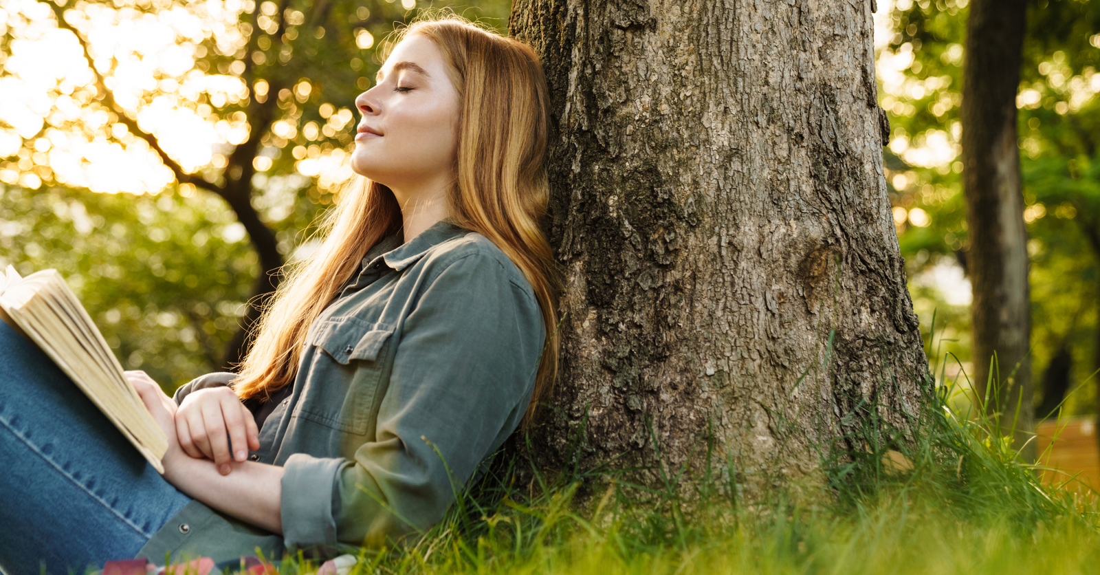 Woman sitting under a tree reflecting