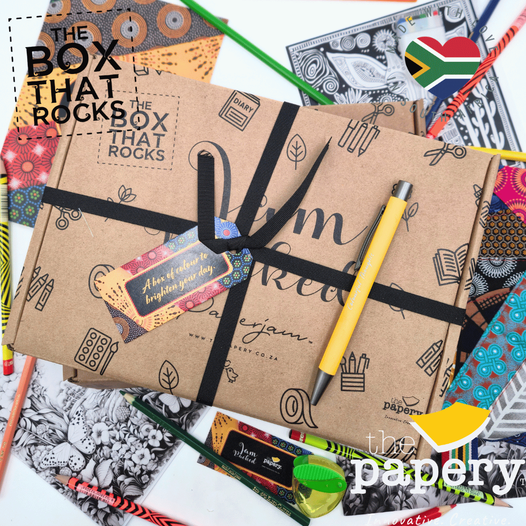 Notebook with decorative cover and pen, surrounded by stationery items, on a white background.