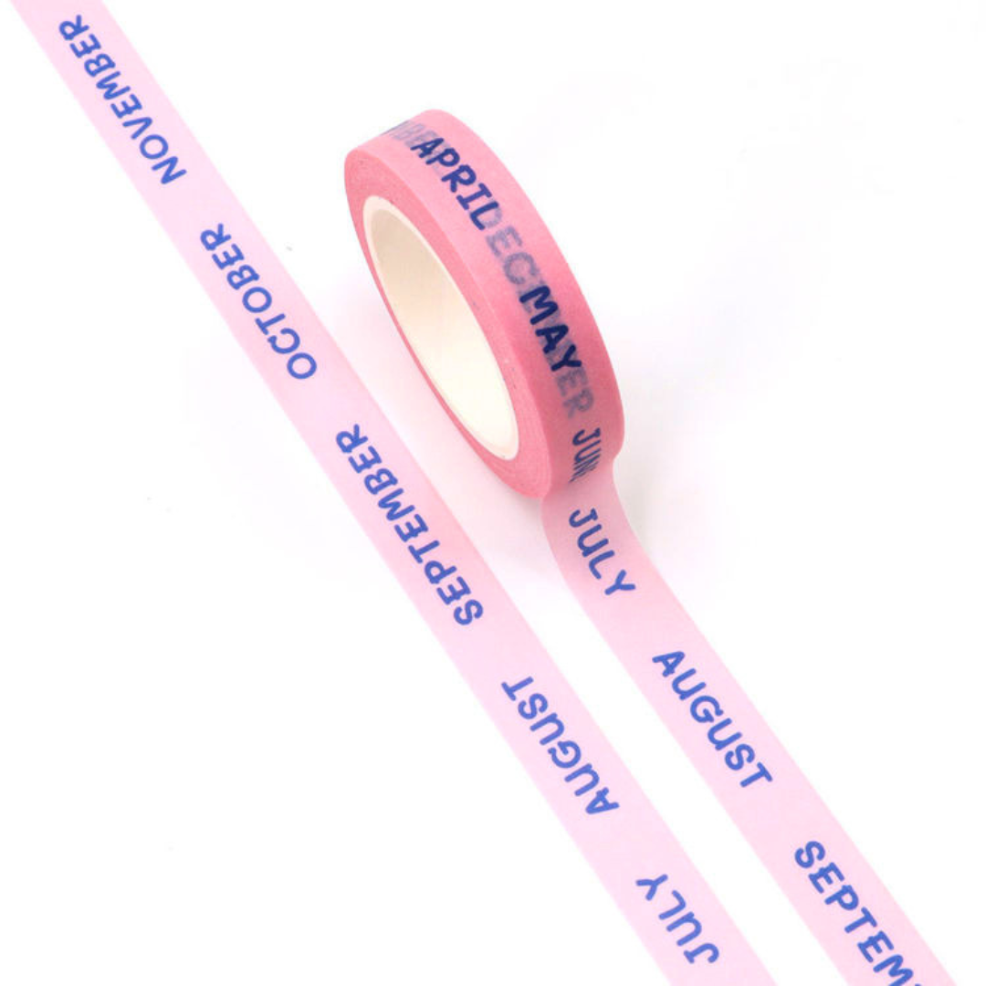 Pink washi tape with months printed on it on a white background