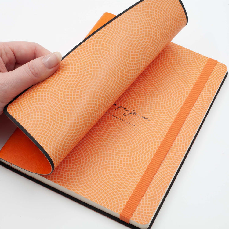 Image shows the endpapers of an orange flexi journal