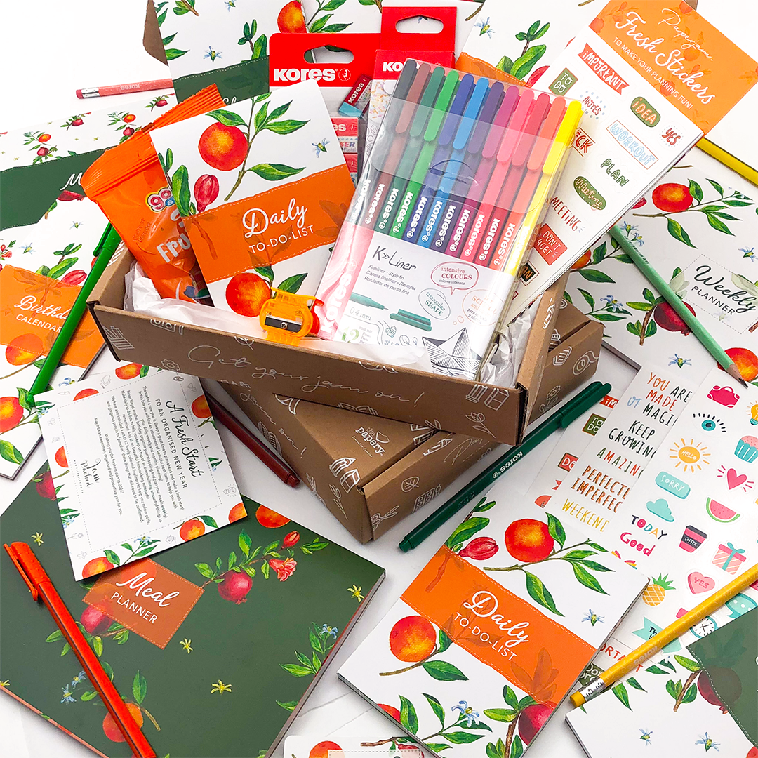 Assorted stationery items including notebooks, pens, and planners in a Fresh Start jam Packed box for new beginning