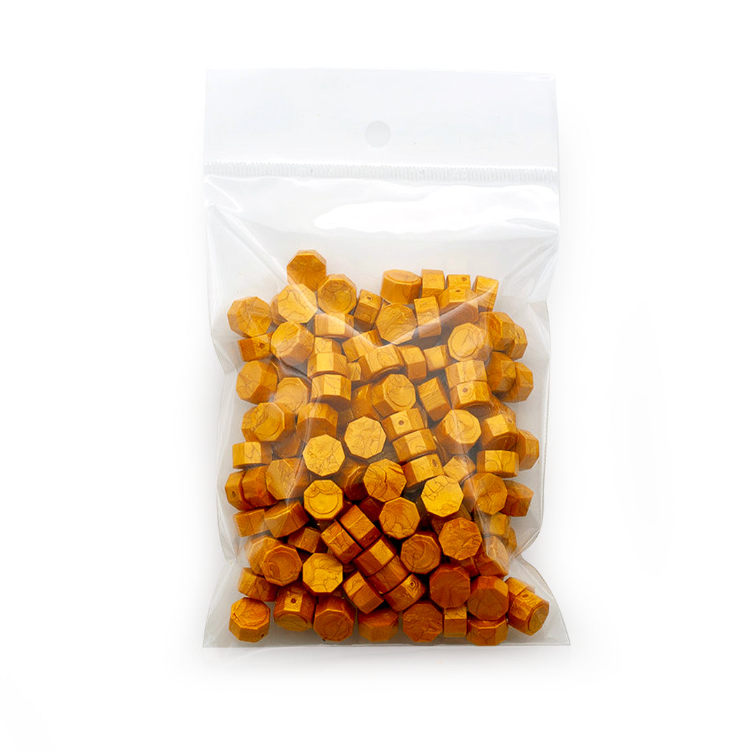 Image shows a pack of gold wax beads