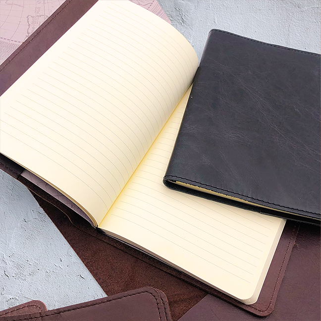 Image shows brown and black slip on leather covers with a journal inner