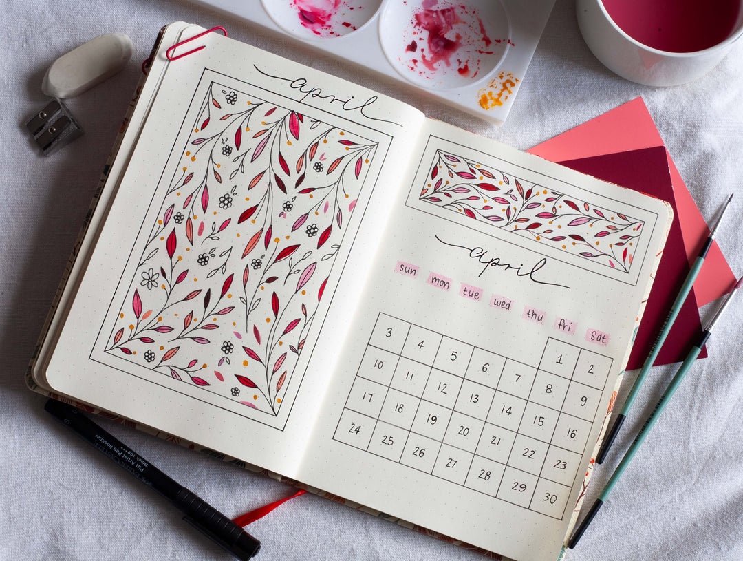 Image shows a journal spread in a premium dotted journal with pink hues 