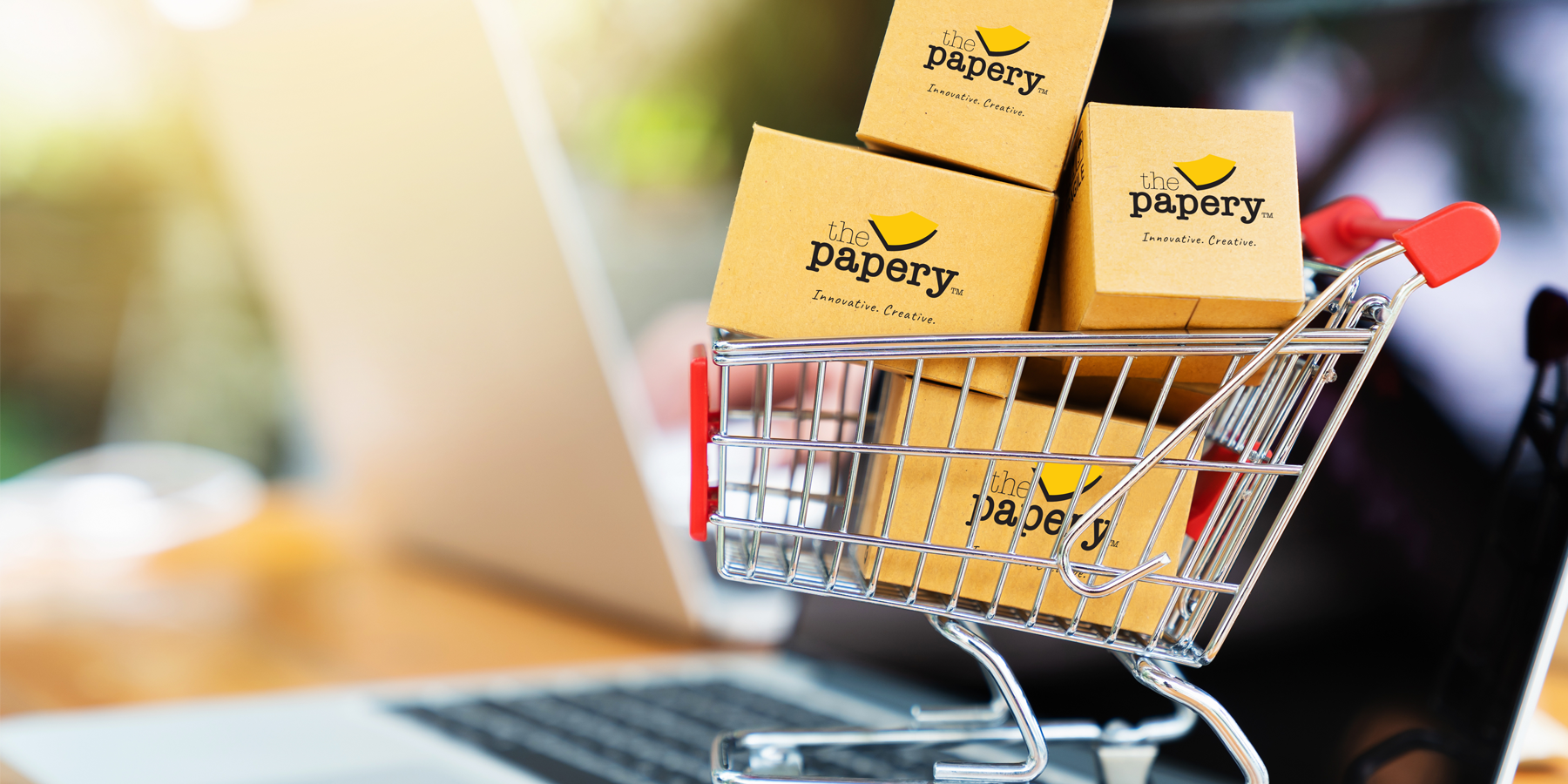 Image shows a shopping cart, holding boxes with "The Papery" logo