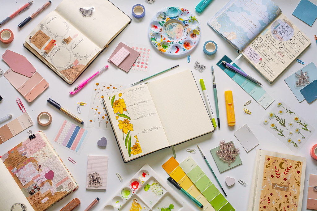 Image shows a desk with various stationery and journals