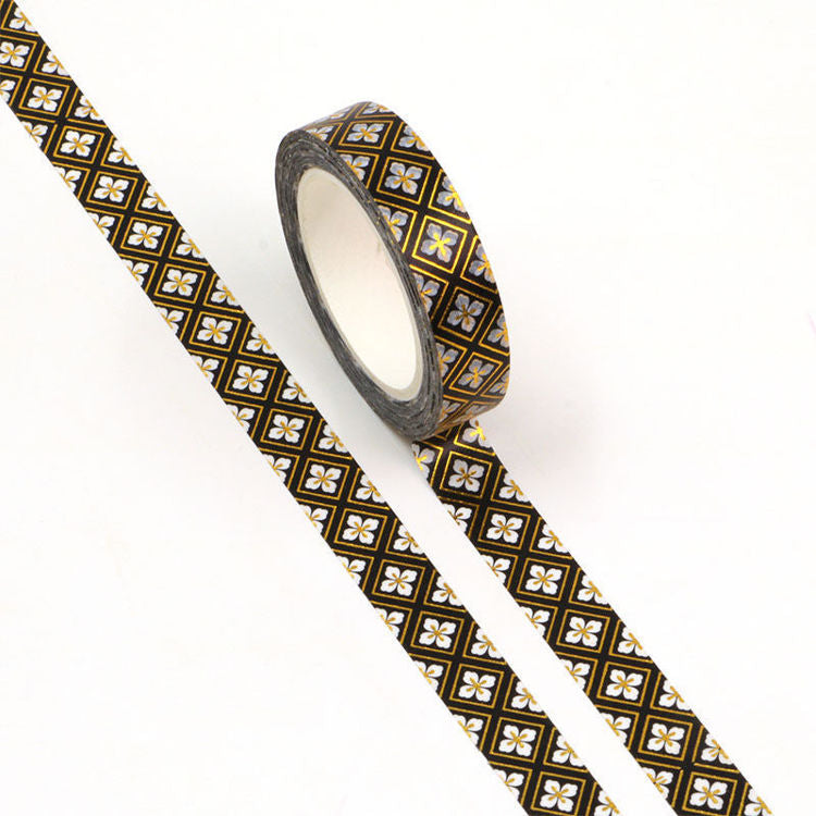Image shows a black and gold pattern washi tape with white daisies