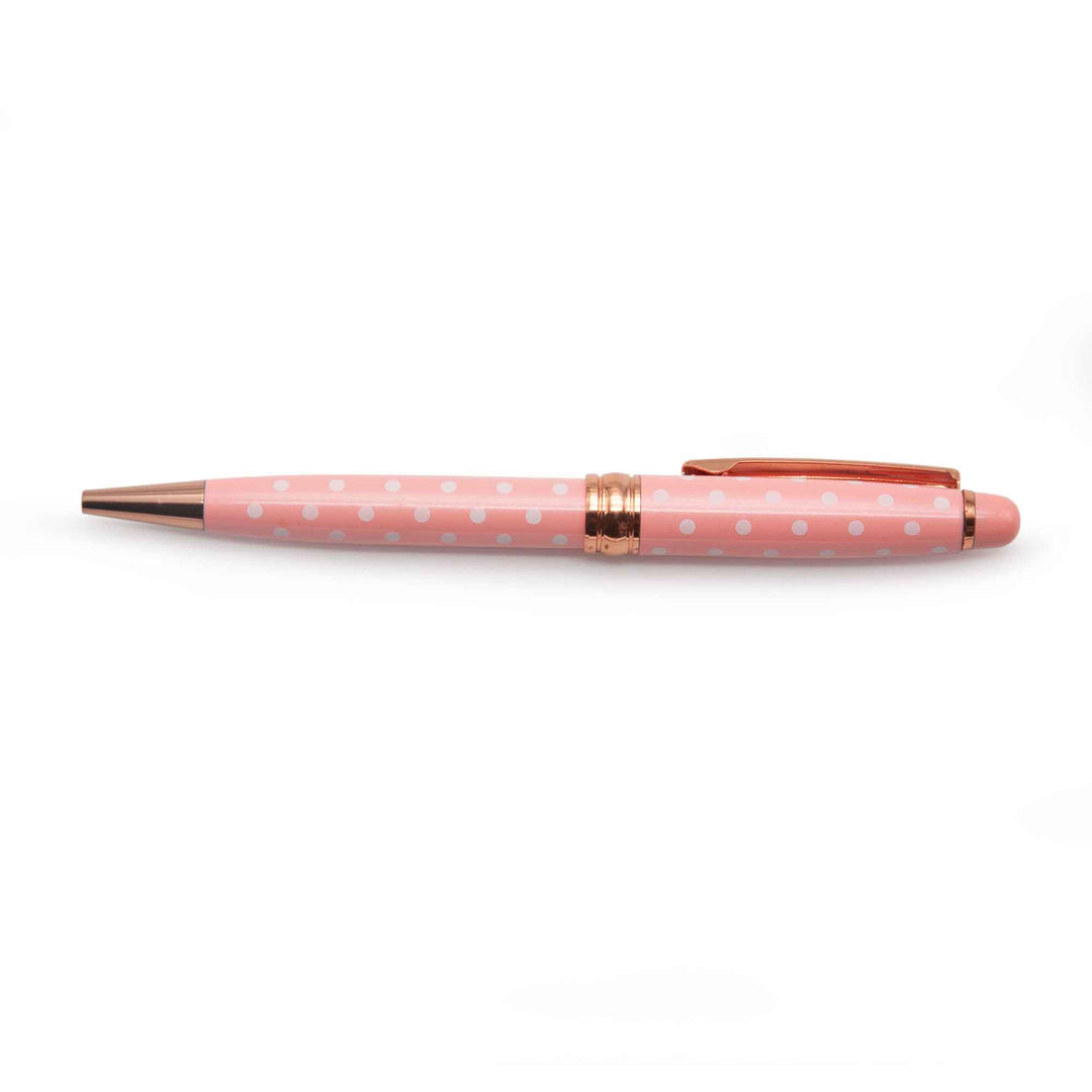 Image shows a pink ballpoint pen with white polka dots